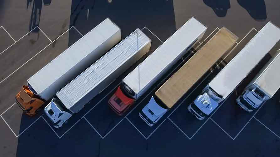 Bildet viser fugleperspektiv av lastebiler oppstilt på en parkeringsplass.